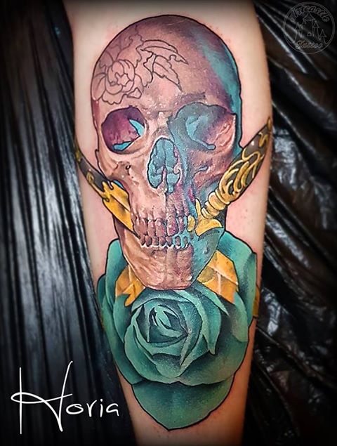 ArtCastleTattoo Tattoo ArtiestHoria Skull with two ornate gold daggers turquoise rose semi realism semi neo traditional full color tattoo Color