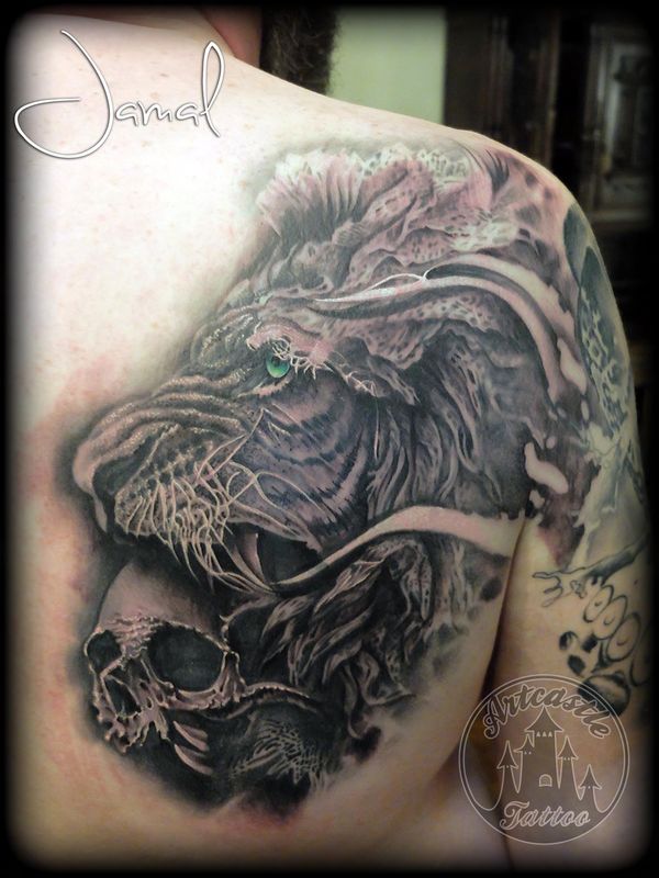 ArtCastleTattoo Tattoo ArtiestJamal Realistic lion with a skull in his mouth its part of a full sleeve with chest piece and back part. In progress. Black n Grey